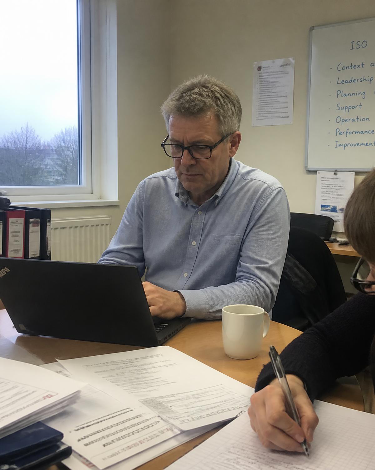 ISO consultant walking a production manager through an engineering workshop